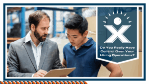 A warehouse manager looking at a clipboard with an employee.